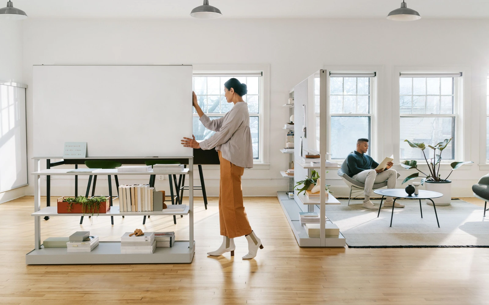 Woman in a sleek modern office moving a whiteboard.